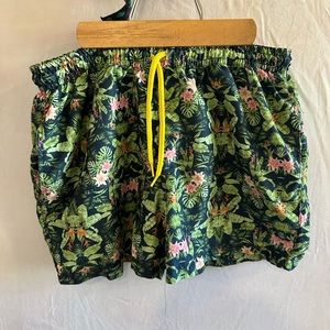 Men’s swimming trunks. Green tropical pattern.